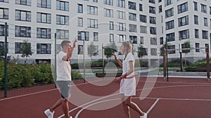 Friendly happy couple celebrates finish of basketball game or victory. They giving five by hands. Training basketball