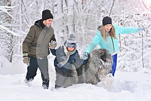 Friendly happy family with pet walking outdoors