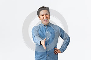 Friendly happy smiling asian man with braces saying nice to meet you, extend hand forward for handshake, greeting