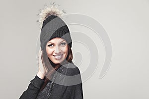 Friendly happy woman wearing a pompom hat