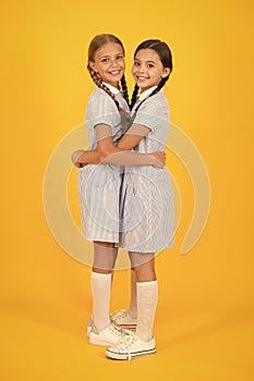 Friendly hug. Beautiful schoolgirls best friends. Back to school concept. Cute schoolgirls. Girls braided hairstyle