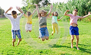 Friendly kids jumping together in park