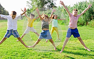 Friendly kids jumping together in park