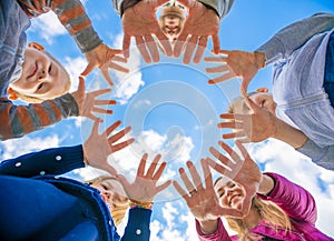 A friendly large family makes a circle shape out of the palms of their hands.