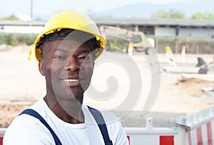 Friendly laughing african worker at construction zone