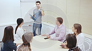 Friendly lawyer sitting with laptop in informal office meeting space, consulting his young female clients