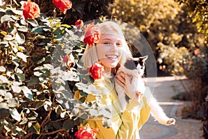 Friendly-looking joyful attractive european woman blonde haircolor smiling holding a cat happily carefree gazing camera