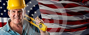 Friendly Male Contractor Wearing Blank Yellow Hardhat Over Waving American Flag Background Banner