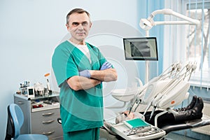 Friendly male dentist with dental equipment in the dental office