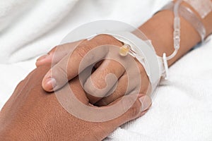 Friendly male hands holding female patient`s hand