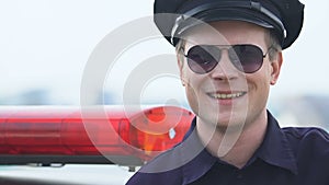 Friendly male police officer looking to camera, trusting police, protection