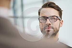 Friendly male professional colleagues greeting handshaking meeting in company office hall