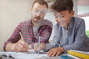 Friendly male teacher helping his little student