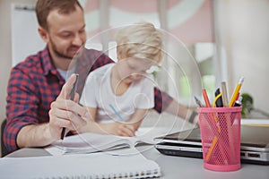 Friendly male teacher helping his little student