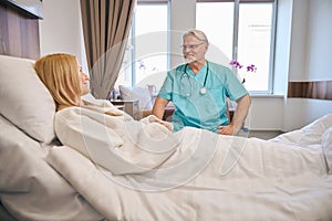 Friendly male therapist talking to beautiful lady patient