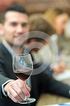 Friendly man holding wine glass