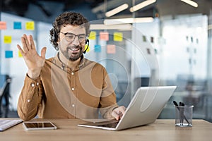 Friendly man waving during a video call on laptop
