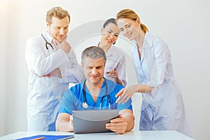 Friendly medical professional looking at laptop and smiling