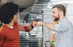 Friendly men coworkers having agreement, givint fist bump