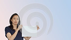Friendly mixed race casual Asian mature woman presenting gesture with copy space for advertising