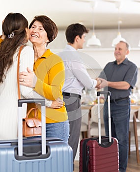 Friendly mother-in-law greeting visiting daughter-in-law with kiss