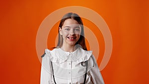 Friendly nice teen girl smiling against yellow background in studio