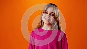 Friendly nice teen girl smiling against yellow background in studio