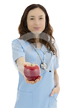 Friendly nurse or doctor reaching out an apple