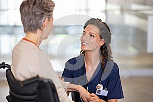 Friendly nurse talking with disabled senior patient