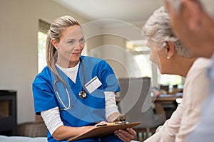 Friendly nurse talking with old couple