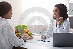 Friendly nutritionist giving consultation to patient about healthy feeding