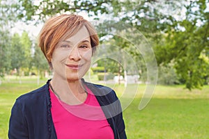 Friendly older woman closeup portrait. Healthy happy elegant elderly woman with red short haircut smiling