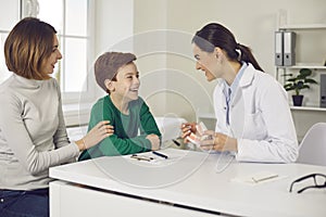 Pediatric dentist consults mother with her young son in the office of a modern dental clinic.