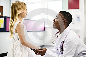 Friendly pediatrician talking to her little patient photo