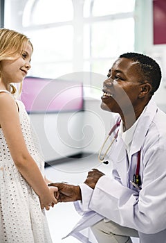 Friendly pediatrician talking to her little patient photo