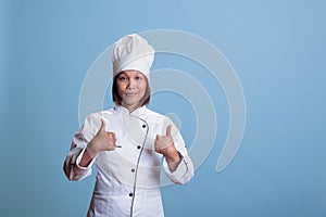 Friendly positive cook doing thumbs up gesture approving gastronomy recipe