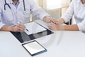 Friendly Professional medical doctor in white uniform coat holding patient hand sitting at the desk for encouragement, cheering