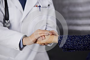 Friendly red-beard doctor reassuring his female patient, close-up. Medical ethics and trust concept, medicine theme