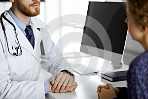 Friendly red-beard doctor reassuring his female patient, close-up. Medical ethics and trust concept, medicine theme