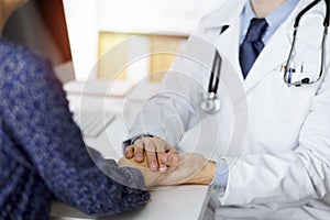 Friendly red-beard doctor reassuring his female patient, close-up. Medical ethics and trust concept, medicine theme