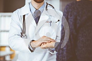 Friendly red-beard doctor reassuring his female patient, close-up. Medical ethics and trust concept, medicine theme