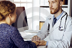 Friendly red-beard doctor reassuring his female patient. Medical ethics and trust concept, medicine theme