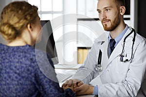 Friendly red-bearded doctor reassuring his female patient. Medical ethics and trust concept, medicine theme