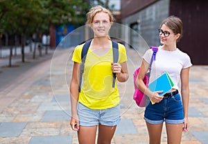 Friendly schoolgirls walking together