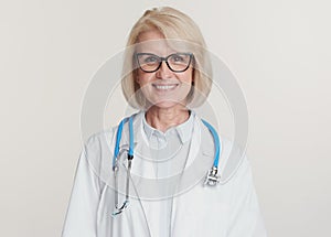 Friendly senior woman doctor is smiling. Isolated