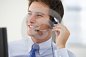 Friendly Service Agent Talking To Customer In Call Centre