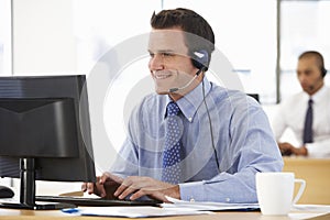 Friendly Service Agent Talking To Customer In Call Centre