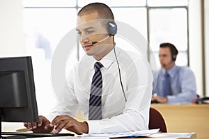 Friendly Service Agent Talking To Customer In Call Centre