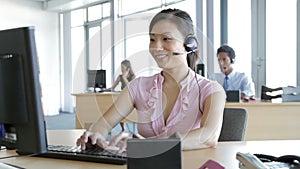 Friendly Service Agent Talking To Customer In Call Centre