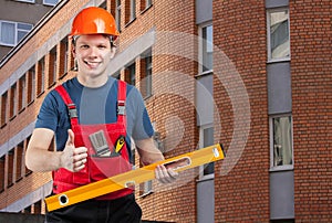 Friendly smiling construction worker showing thumbs up